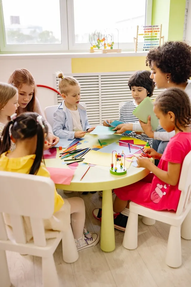 early education students doing arts and crafts on circular table