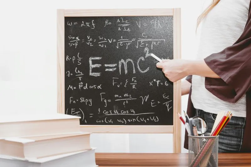 Child writing on board with teacher